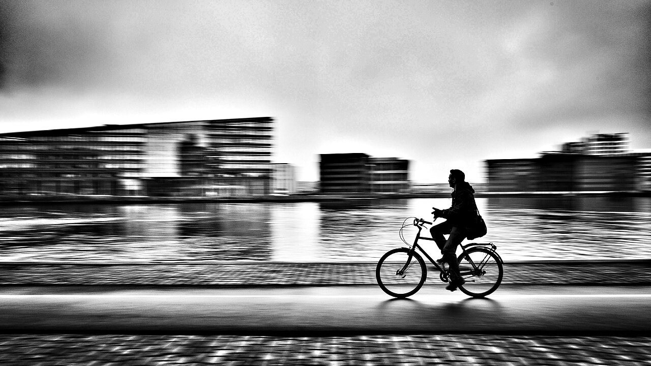Panning shot of a cyclist sharp against a motion-blurred background
