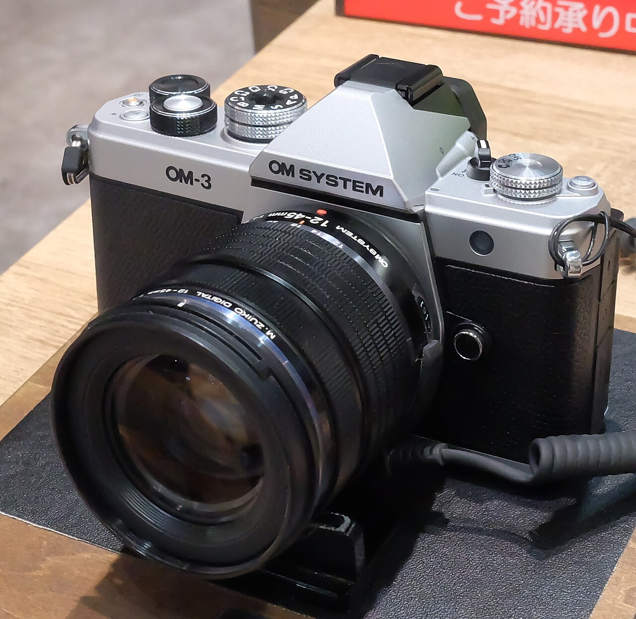 OM System OM-3 mirrorless camera with lens
