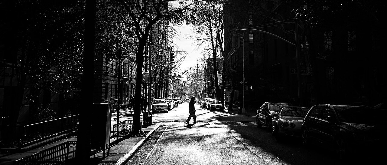 Black and white street photograph of pedestrians crossing a New York City street
